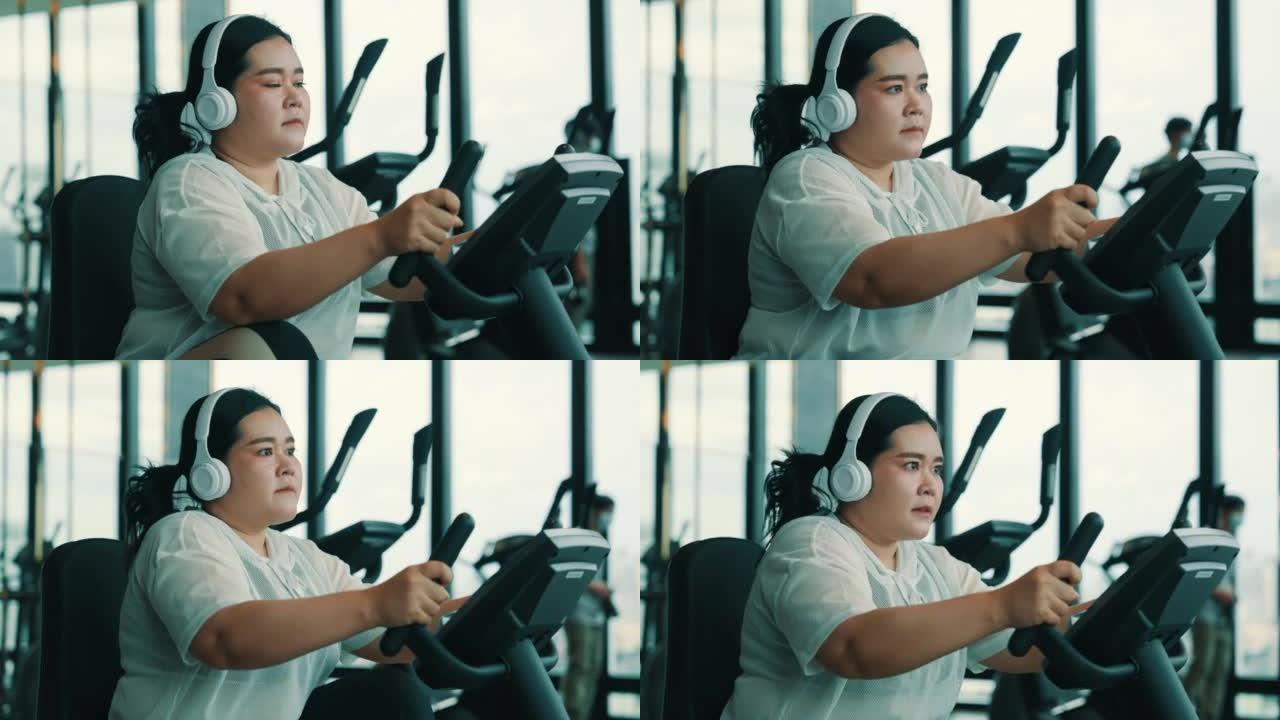 大型女性在健身车上锻炼时听音乐
