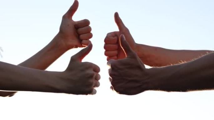 许多手示意拇指。团队合作理念。人群中许多人竖起大拇指，表示同意和支持。团队合作志愿或生活方式投票