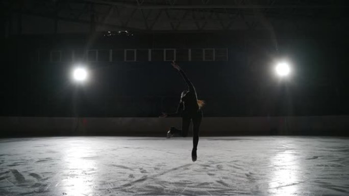 溜冰者在室内溜冰场训练。在体育场进行花样滑冰。女人表演花样滑冰，后退旋转的元素。