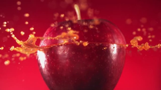 半红苹果掉落并溅到紫红色背景上。食物悬浮概念。慢动作
