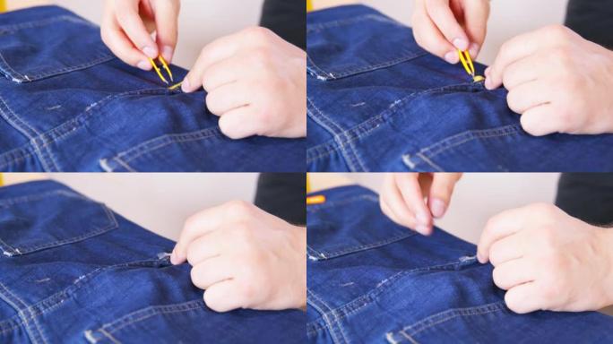 一个人用镊子从胶带上取下保护膜，用双面胶带将接缝处撕裂的牛仔裤粘合起来。无能的人修理破衣服，侧视图。