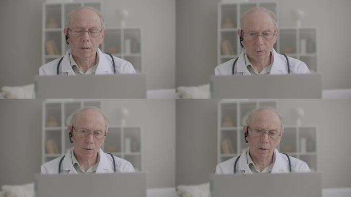 老年医学教授正在使用笔记本电脑在他的办公室为患者和实习学生提供在线咨询