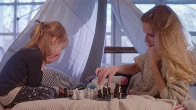 母女俩在舒适的天篷床上下棋