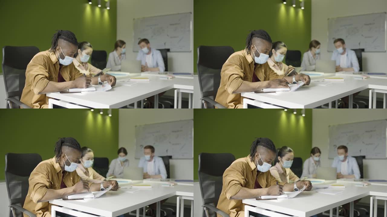 新型冠状病毒肺炎大流行期间戴着防护口罩的办公室工作人员，注意事项