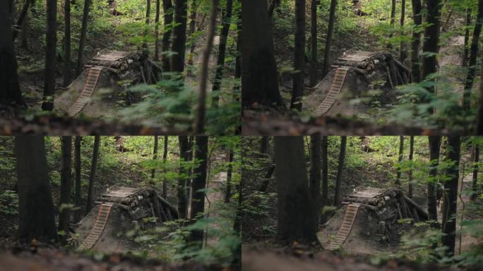 山地自行车上的森林自行车手的电影镜头加速并跳上跳板