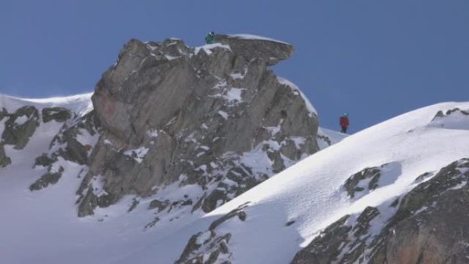山顶上的三个滑雪者等待下山