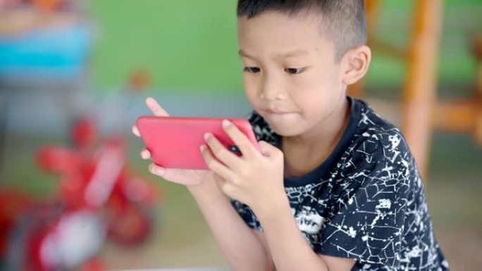 玩手机的亚洲孩子。