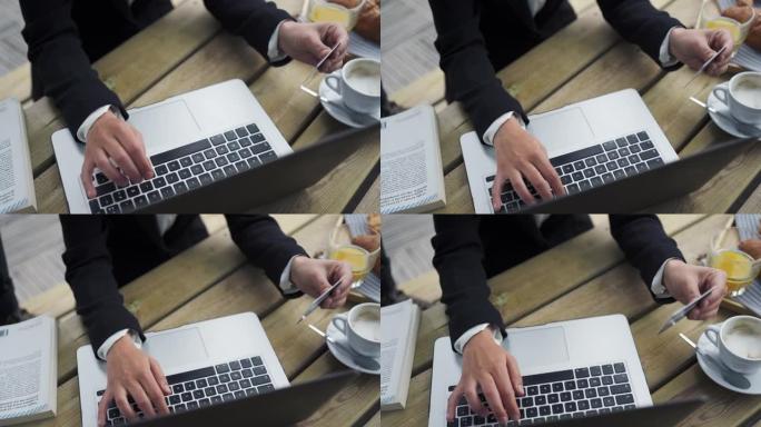 女商人在笔记本电脑上打字，拿起一杯咖啡