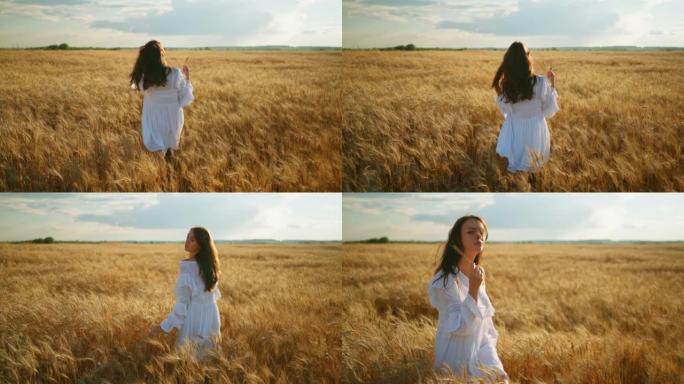 优雅的白衣女子独自走在成熟的金色黑麦田里，欣赏着自然景观