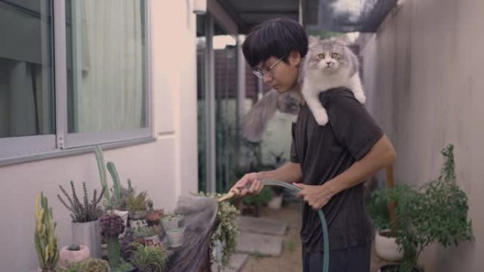男人和他的猫在户外花园里浇水
