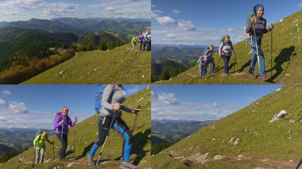 一群女性徒步旅行者在阳光明媚的日子里走在风景秀丽的山间小径上