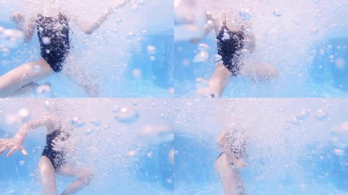 穿着泳衣的女孩在蓝色水池上游泳，水下上升的气泡，慢动作