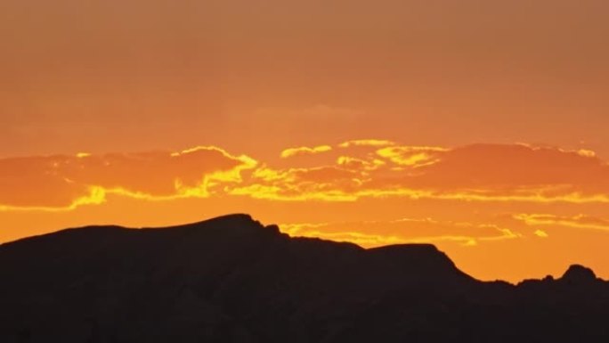 日出时美国内华达州山脉后面的空中金色天空