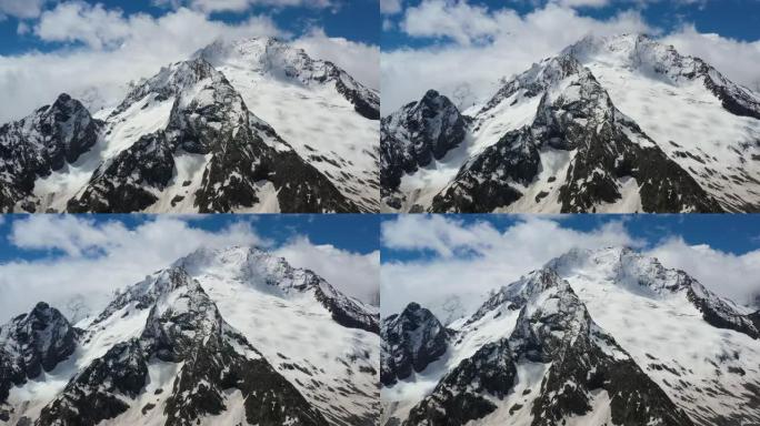 空中飞行穿过山云，飞越美丽的白雪皑皑的山峰和冰川。