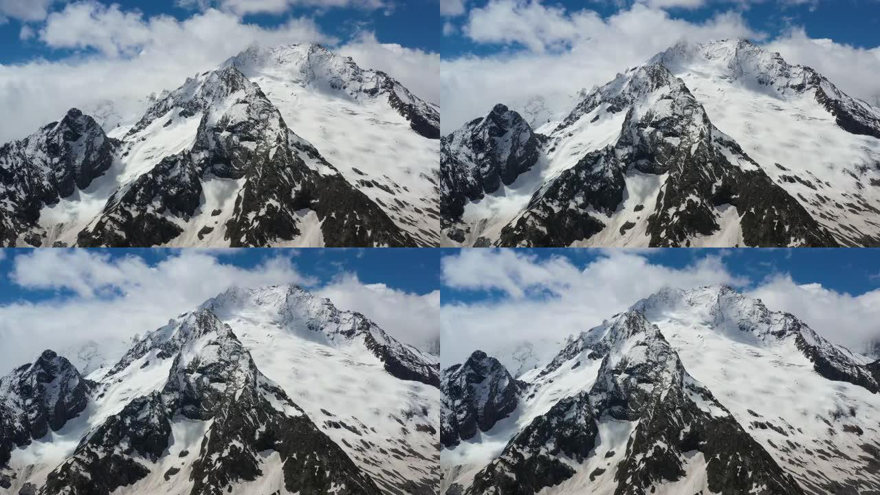 空中飞行穿过山云，飞越美丽的白雪皑皑的山峰和冰川。