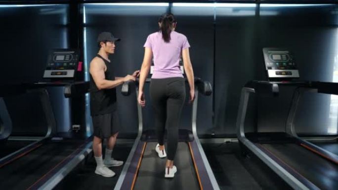 亚洲男老师教健身年轻女性开始使用健身房。