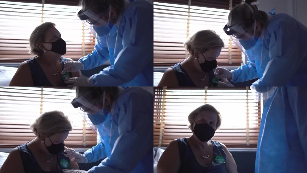贴纸 “fui vacinado' (接种疫苗) 被一名在家中的医生粘在一名高级妇女身上-戴着口罩