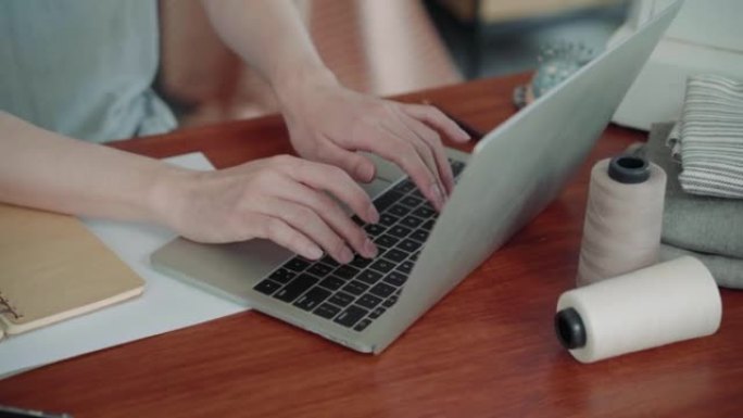 关闭手在桌子上打字键盘，企业主通过使用笔记本电脑现代技术打字或与客户聊天，企业家在家庭办公室确认客户