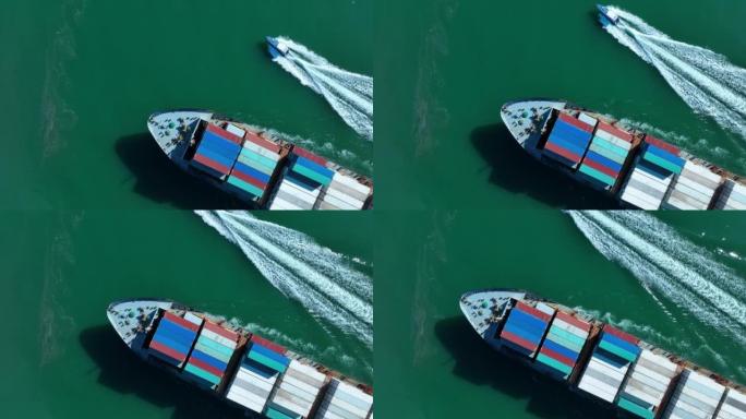 货船运载集装箱和在领航船附近运行的货船的空中俯视图，用于从堆码港到海关海港的出口进口货物概念技术物流