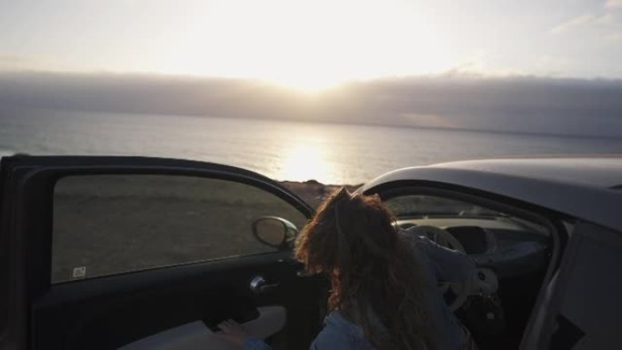 特写镜头，一名妇女在停车时从汽车上望向大海