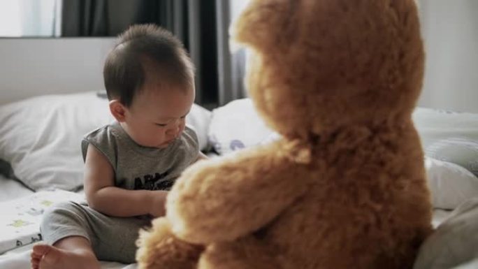 小男婴在家玩柔软的泰迪熊玩具