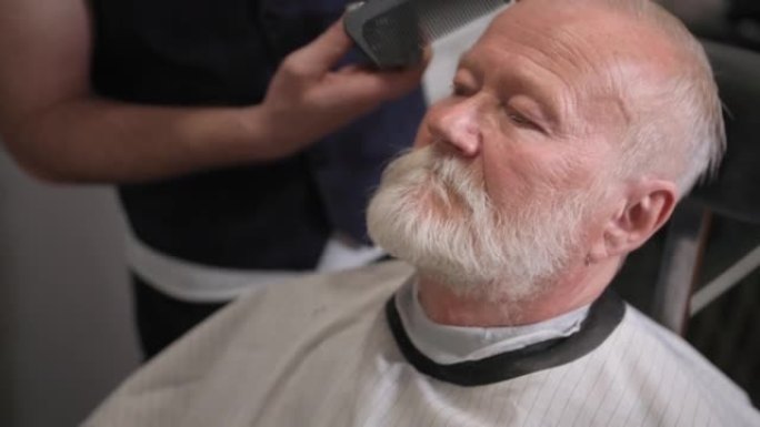 现代白发老人在理发店做头发和胡子的剪发和造型，特写