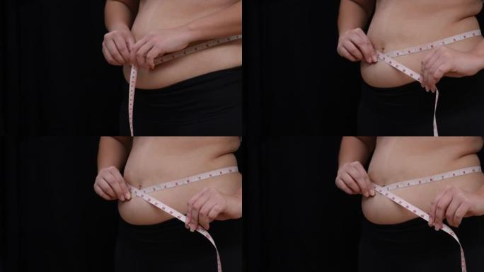 超重的女人用复制空间测量腹部
