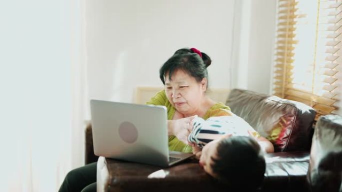 小儿子和奶奶玩笔记本电脑上的视频剪辑。