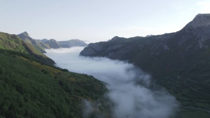 空中无人机在群山环绕的山谷中拍摄低矮的云层