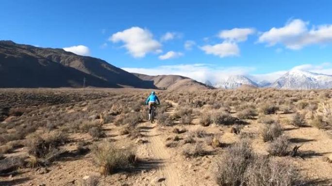 女性山地自行车手沿着沙漠小路