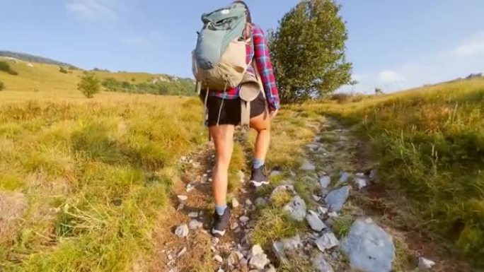 TS女人走在阳光明媚的山路上