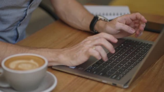 男双手的商人，专业的用户，工人使用笔记本电脑上打字，笔记本键盘，坐在家里的办公室办公桌上工作，与pc