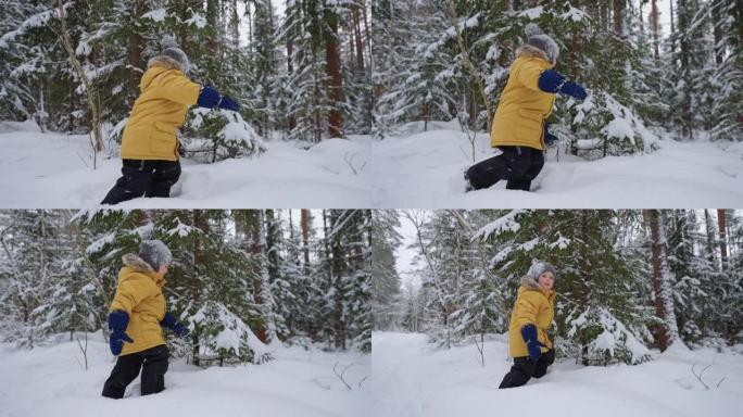 一个穿着黄色外套的男孩穿过深雪，研究冬季森林，冬季行走，并以慢动作穿过雪林。儿童自由环境的概念