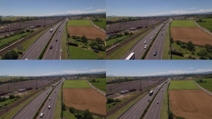 在晴朗的日子里，空中无人机拍摄了一条繁忙的高速公路，穿过农村农田