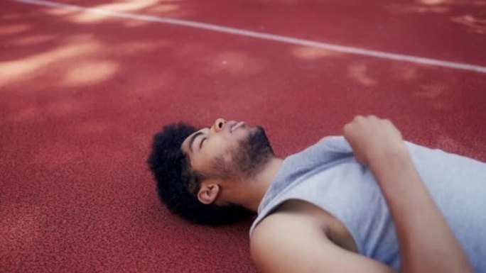 疲惫的男篮运动员躺在球场上休息时间积极的生活方式