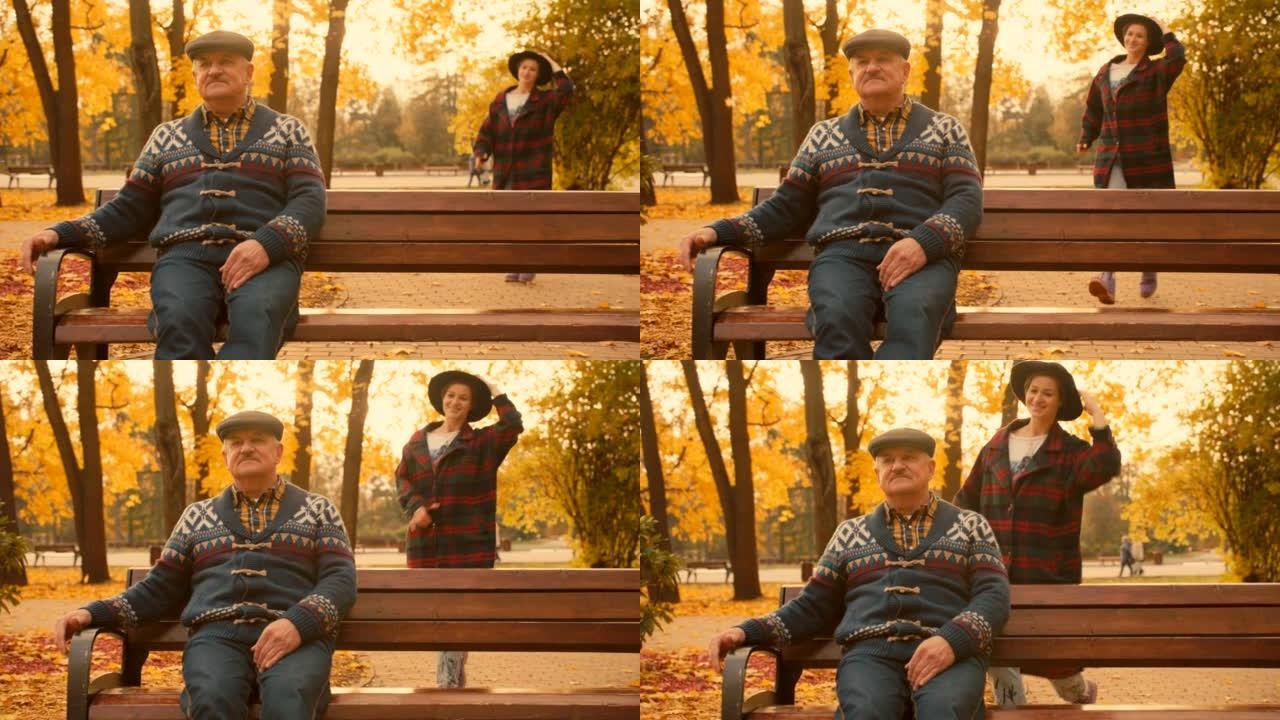 秋天在城市公园与成年女儿见面的高级男子。美丽的秋天自然和背景上的日落