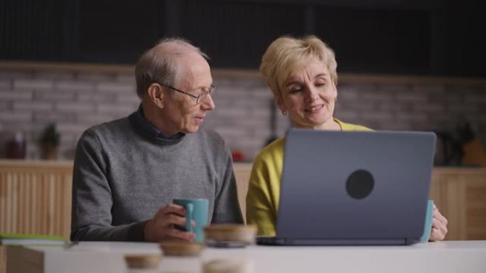 通过视频通话进行在线交流，老人和他的妻子正在与朋友和家人聊天，在家中使用带有互联网连接的笔记本电脑