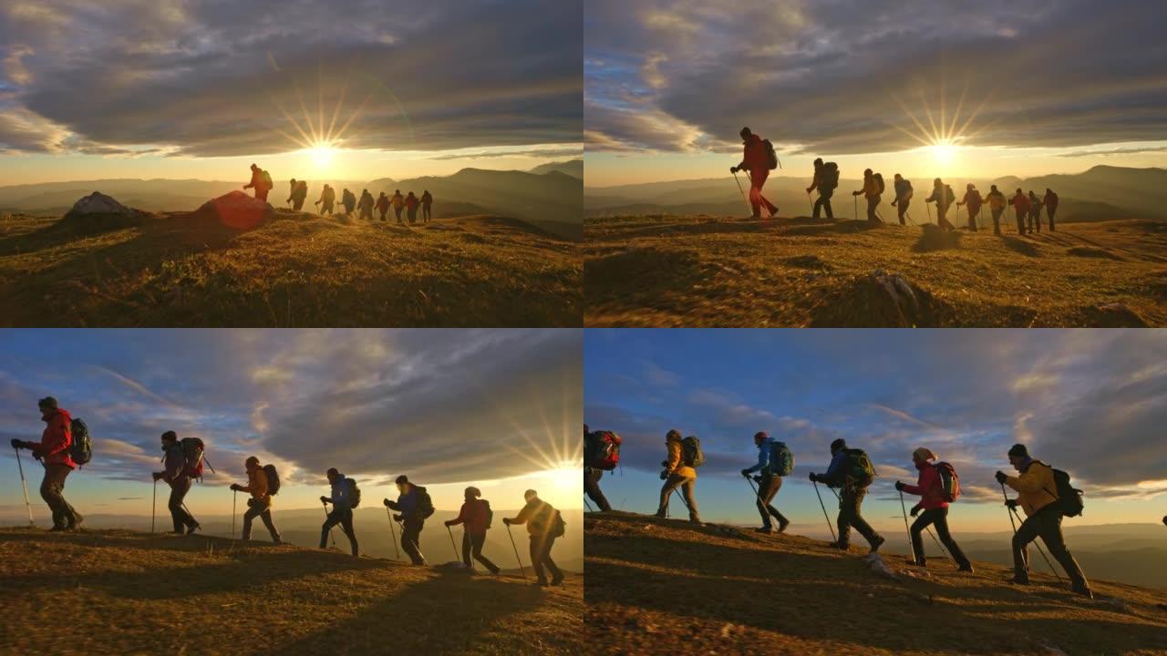 空中SLO MO远足团体在日落时在山顶行走