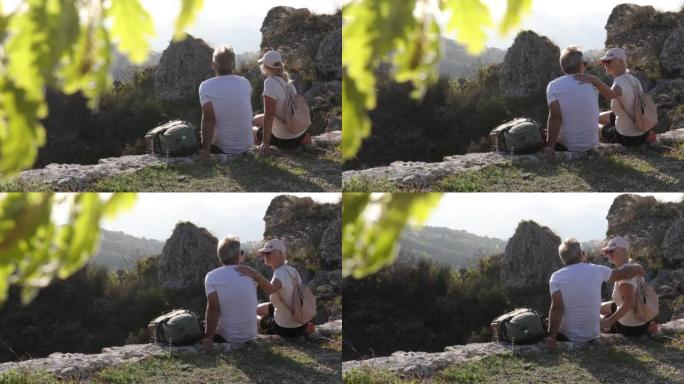 徒步旅行夫妇在岩石壁架上放松，看着