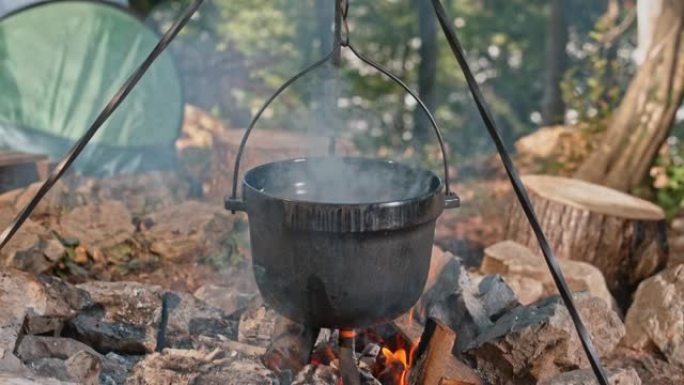 SLO MO食物在森林篝火上的铸铁锅中煮熟