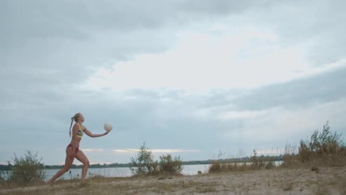 沙滩排球运动员女子正在大自然中训练发球，慢动作全程射门
