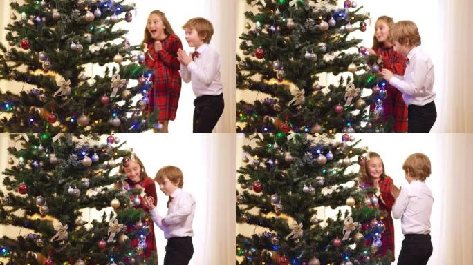 家里装饰着圣诞树，兴奋的孩子们奔向新年的枞树，微笑着鼓掌说话。新年快乐的高加索兄弟姐妹在客厅。庆祝。
