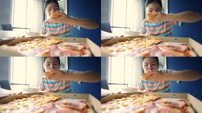 亚洲少女在家享用披萨。