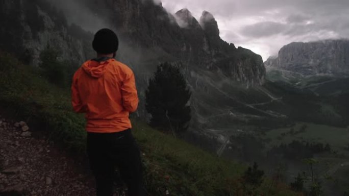 在寒冷的雾蒙蒙的日落中，男子摄影师在白云岩的高山上徒步旅行