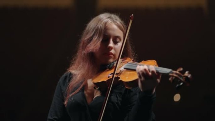 女小提琴家在音乐学校拉小提琴，音乐家在演奏古典或新古典音乐