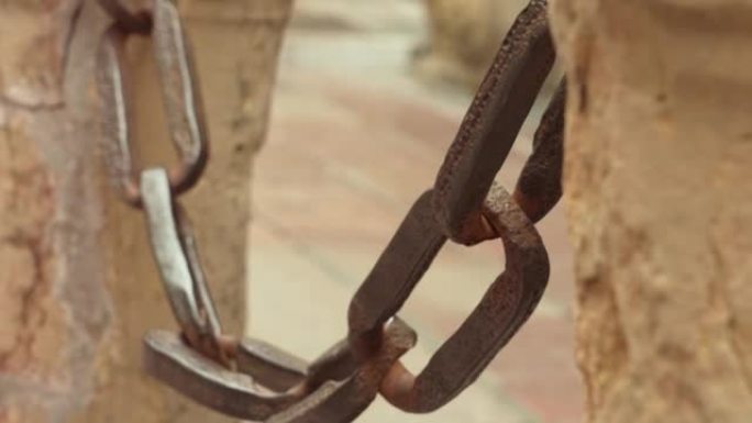 古老的铁链，整个链接在港口的古董石柱上。生锈的纹理