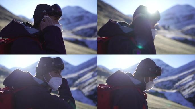 穿着滑雪服的男子在瑞士山区戴上健康口罩