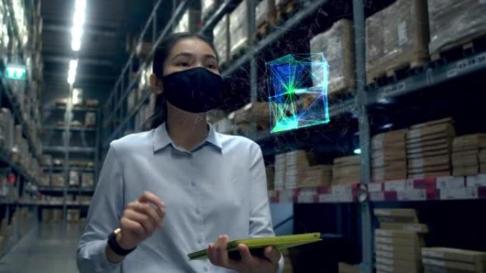 亚洲女性在仓库的平板电脑检查工作中使用全息图大数据保护程序。