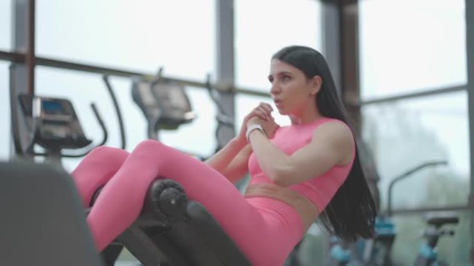 女运动员在长凳上锻炼腹肌。用身体概念进行腹部训练。在长凳上做仰卧起坐