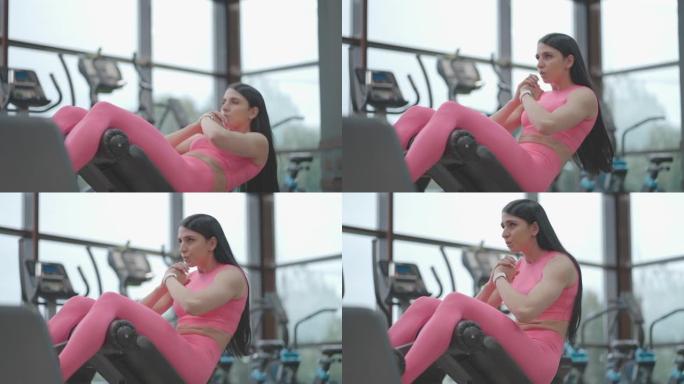 女运动员在长凳上锻炼腹肌。用身体概念进行腹部训练。在长凳上做仰卧起坐
